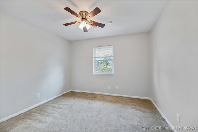 unfurnished room with light colored carpet and ceiling fan