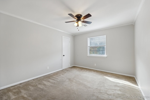 spare room with light carpet, ornamental molding, and ceiling fan