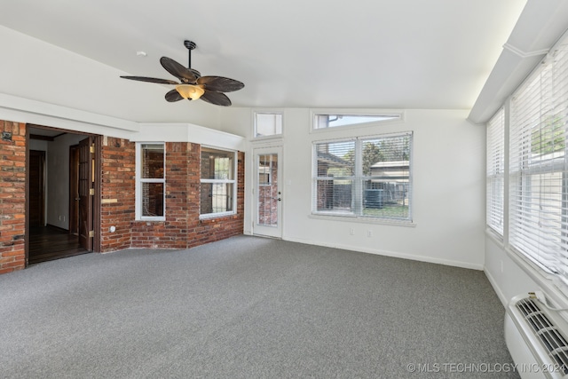 unfurnished sunroom featuring ceiling fan, lofted ceiling, plenty of natural light, and a wall mounted air conditioner