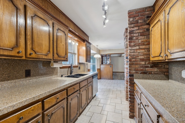 kitchen with tasteful backsplash, sink, decorative light fixtures, and dishwasher