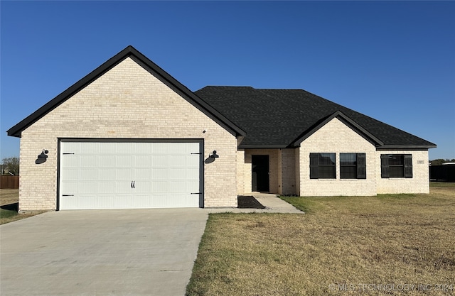 view of front of home with a front yard and a garage