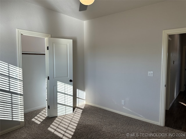 interior space featuring ceiling fan and dark carpet