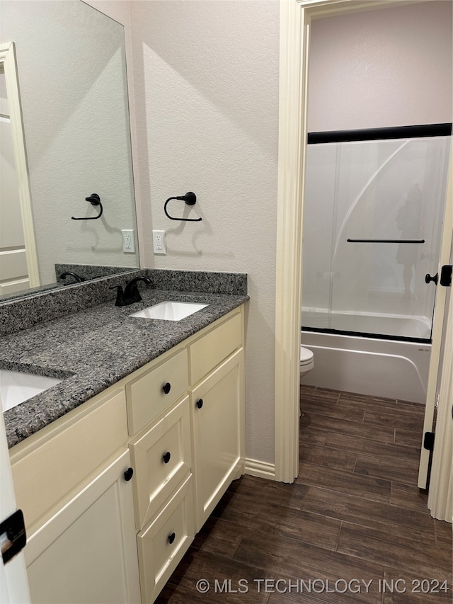 full bathroom featuring vanity, toilet, shower / bath combination with glass door, and hardwood / wood-style floors