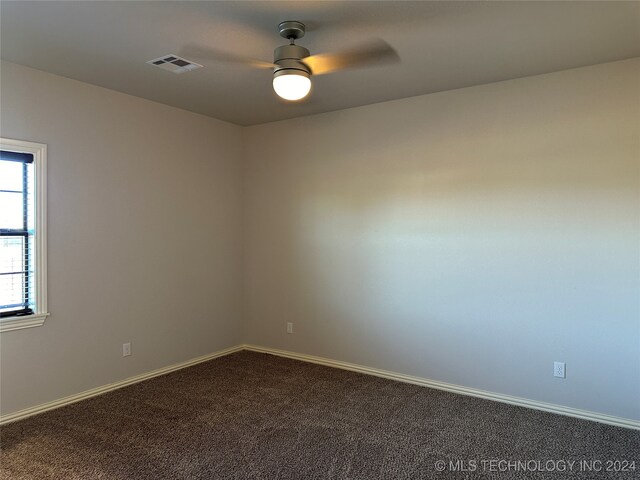 carpeted spare room featuring ceiling fan