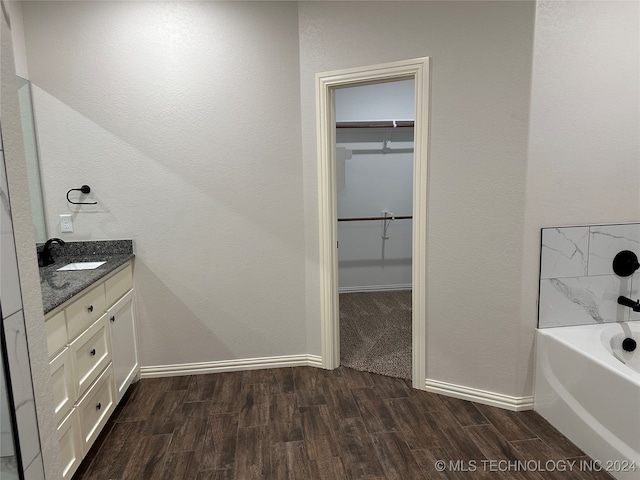 bathroom with vanity, a tub to relax in, and hardwood / wood-style flooring