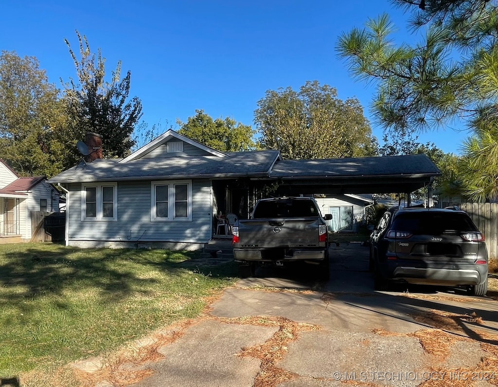 single story home featuring a front lawn and a carport