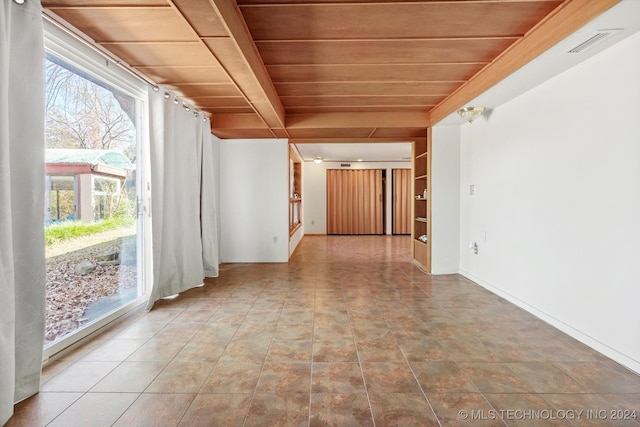 unfurnished room featuring light tile patterned flooring and wooden ceiling