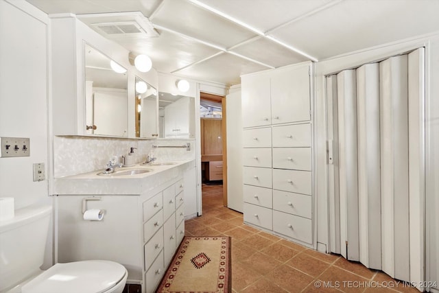 bathroom with vanity, toilet, and decorative backsplash