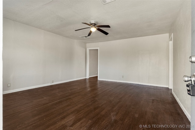 unfurnished room with a textured ceiling, dark wood-type flooring, and ceiling fan