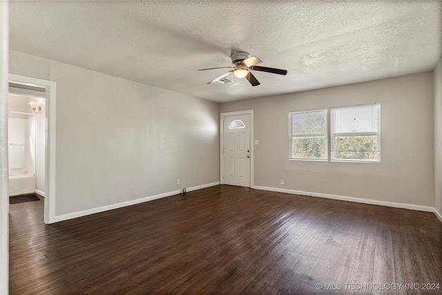 spare room with dark wood-type flooring, ceiling fan, and a textured ceiling