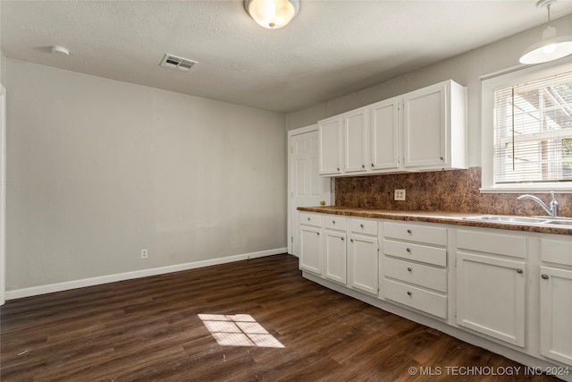 kitchen featuring white cabinets, backsplash, dark hardwood / wood-style flooring, a textured ceiling, and sink