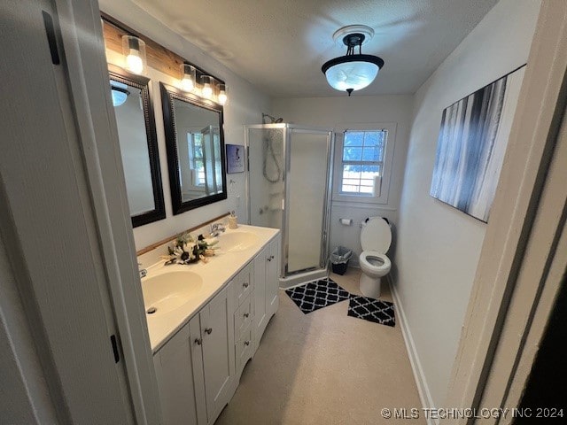 bathroom featuring vanity, a shower with shower door, and toilet