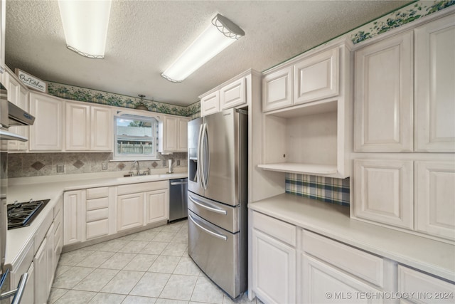 kitchen featuring white cabinetry, light tile patterned floors, appliances with stainless steel finishes, and sink