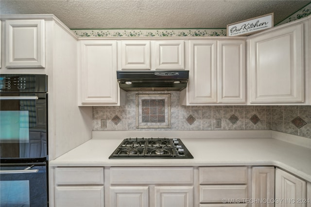 kitchen featuring double oven, gas cooktop, decorative backsplash, white cabinetry, and a textured ceiling