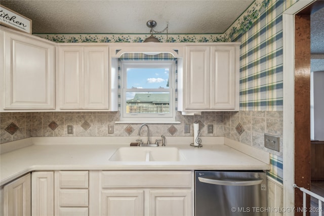 kitchen with a textured ceiling, sink, and stainless steel dishwasher