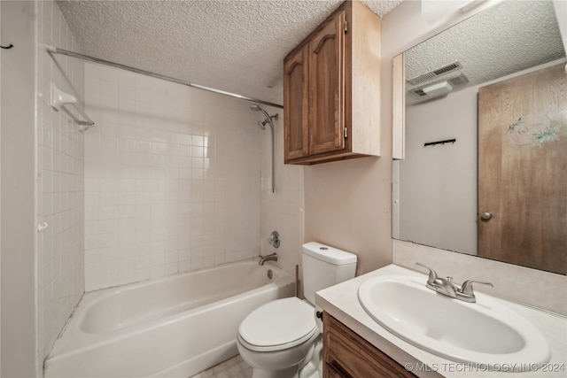 full bathroom with vanity, toilet, tiled shower / bath combo, and a textured ceiling