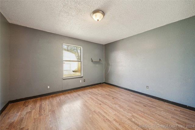 empty room featuring light hardwood / wood-style flooring and a textured ceiling