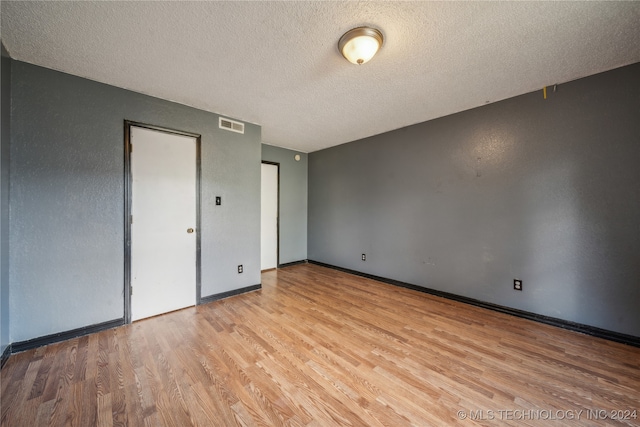 unfurnished bedroom with light hardwood / wood-style flooring and a textured ceiling