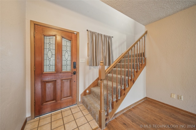 foyer featuring light hardwood / wood-style flooring and a textured ceiling