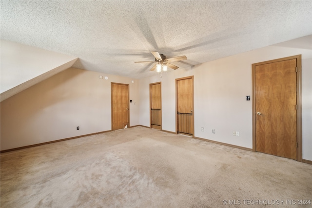 additional living space with a textured ceiling, light colored carpet, and ceiling fan