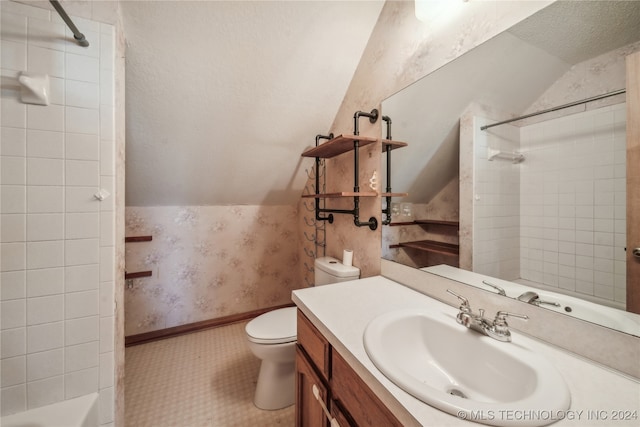 full bathroom with a textured ceiling, toilet, lofted ceiling, vanity, and tiled shower / bath combo