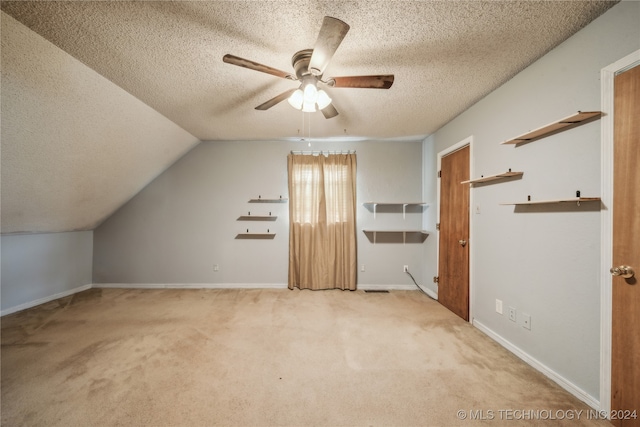 bonus room featuring lofted ceiling, a textured ceiling, light colored carpet, and ceiling fan