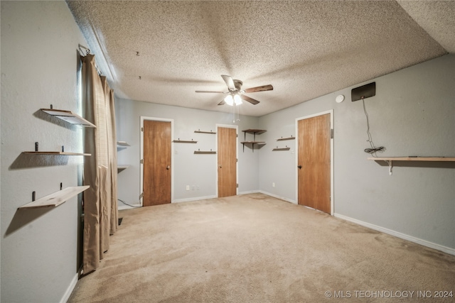 spare room with ceiling fan, a textured ceiling, and carpet flooring