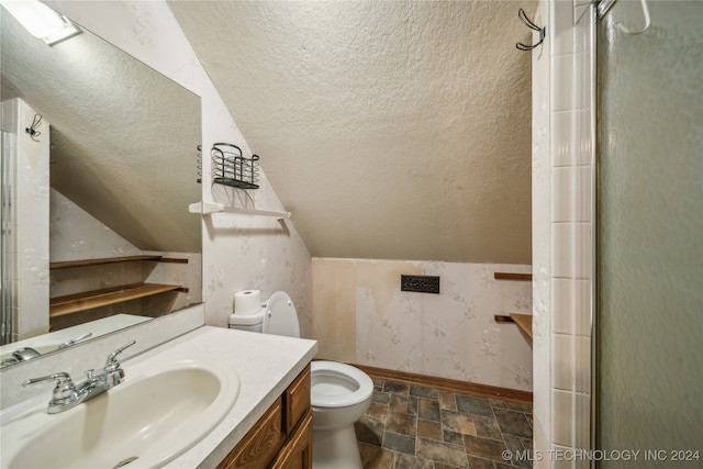 bathroom featuring lofted ceiling, a textured ceiling, walk in shower, toilet, and vanity