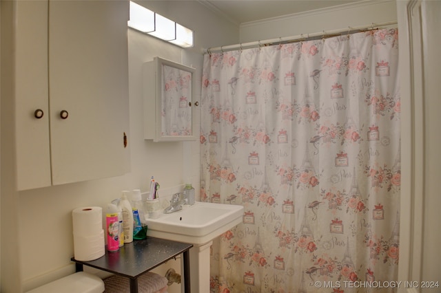 bathroom with a shower with shower curtain, toilet, ornamental molding, and sink