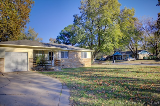 ranch-style home with covered porch, a front yard, and a garage