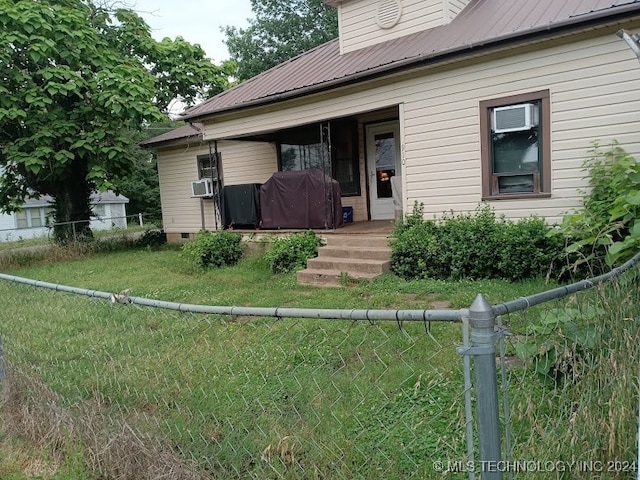 view of front of property with a front yard and cooling unit