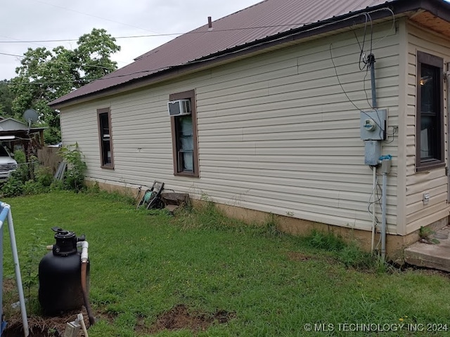 view of home's exterior featuring a wall mounted AC and a yard