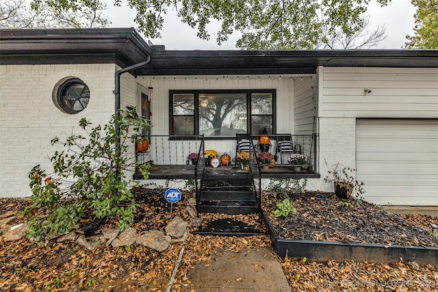 property entrance with a garage and covered porch