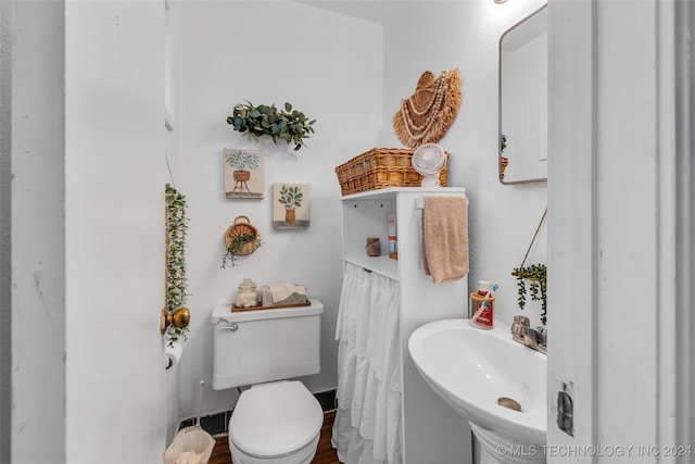 bathroom with hardwood / wood-style floors, sink, and toilet