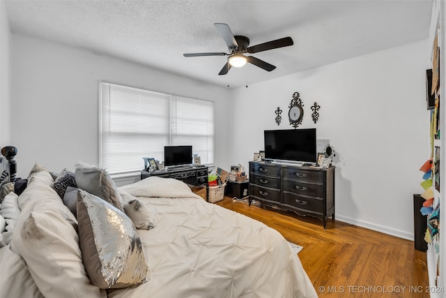 bedroom featuring light hardwood / wood-style floors, ceiling fan, and a textured ceiling