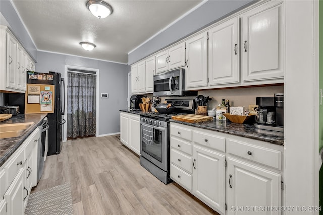 kitchen with white cabinetry, light hardwood / wood-style flooring, appliances with stainless steel finishes, and a textured ceiling