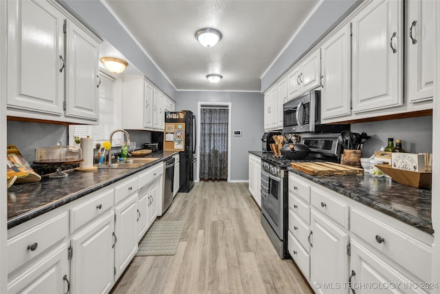 kitchen featuring stainless steel appliances, white cabinets, sink, and light hardwood / wood-style flooring