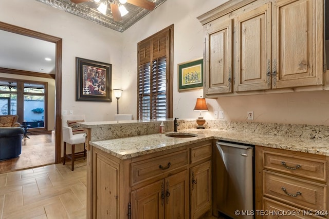 kitchen with sink, ceiling fan, light stone countertops, ornamental molding, and kitchen peninsula