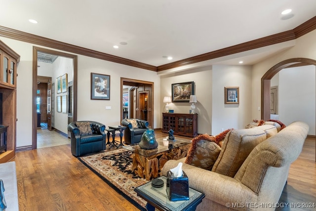 living room with crown molding and light hardwood / wood-style flooring