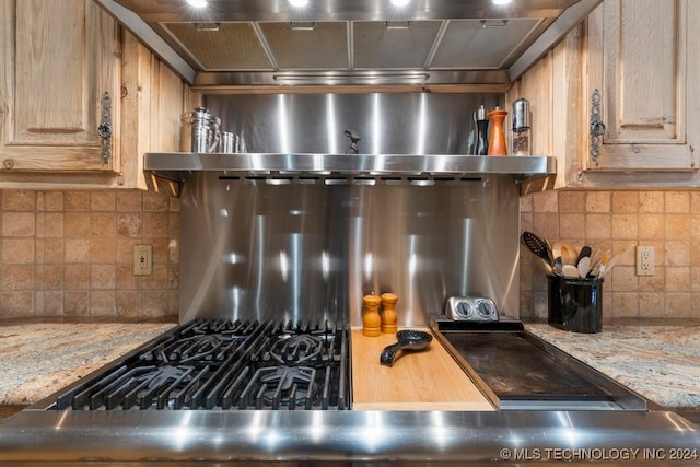 kitchen featuring tasteful backsplash and light stone counters