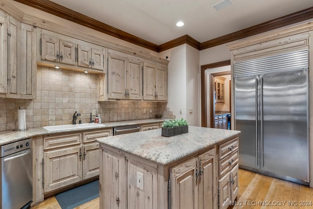 kitchen with tasteful backsplash, appliances with stainless steel finishes, crown molding, a kitchen island, and light wood-type flooring