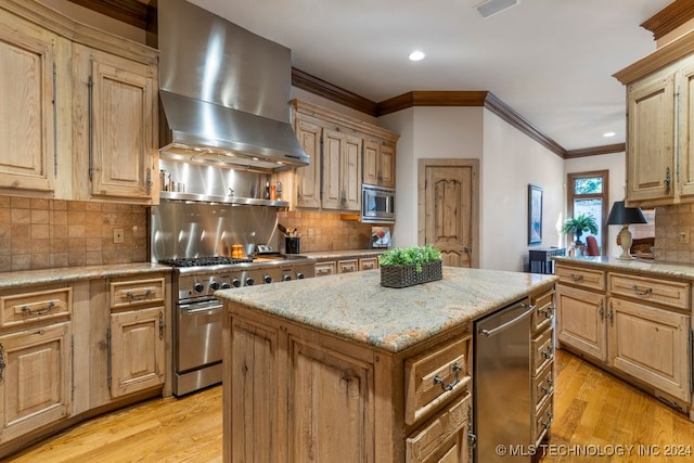 kitchen featuring a center island, wall chimney exhaust hood, light hardwood / wood-style flooring, backsplash, and appliances with stainless steel finishes