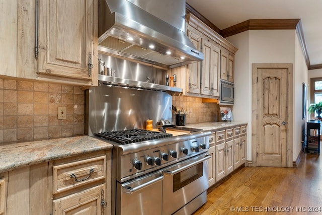 kitchen with decorative backsplash, ornamental molding, wall chimney exhaust hood, stainless steel appliances, and light hardwood / wood-style floors