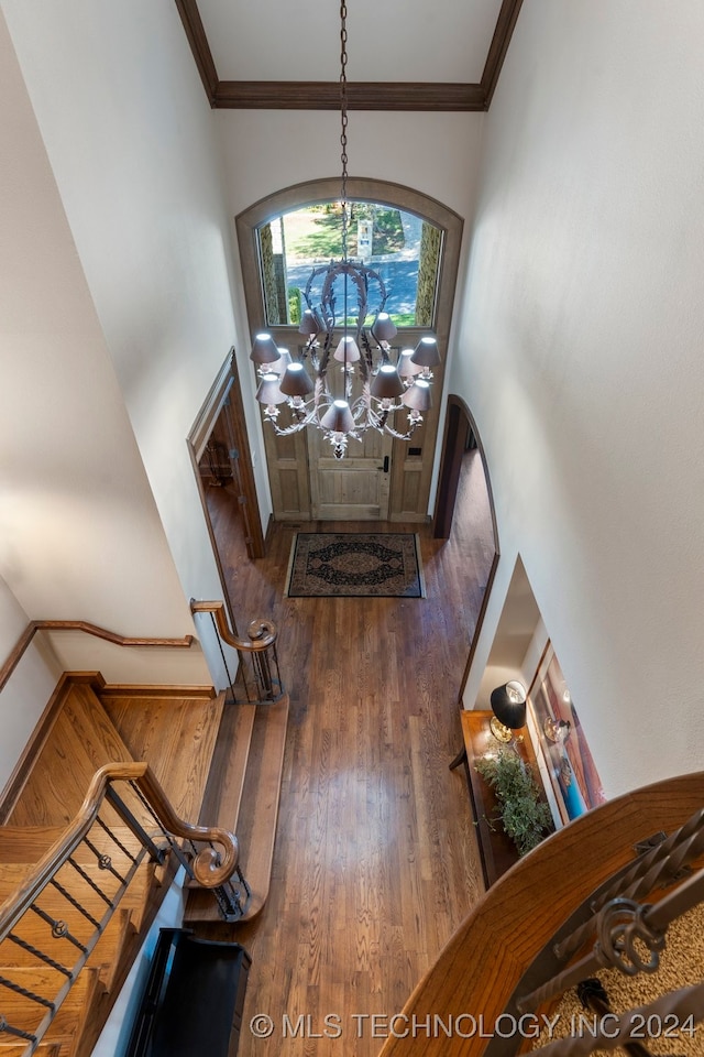 entryway featuring dark hardwood / wood-style floors, ornamental molding, and an inviting chandelier