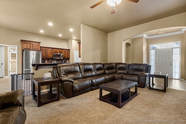 tiled living room with crown molding and ceiling fan