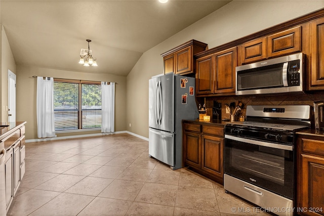 kitchen featuring light tile patterned floors, appliances with stainless steel finishes, vaulted ceiling, and a chandelier