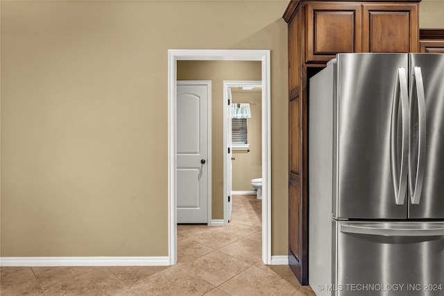 kitchen with light tile patterned floors and stainless steel refrigerator