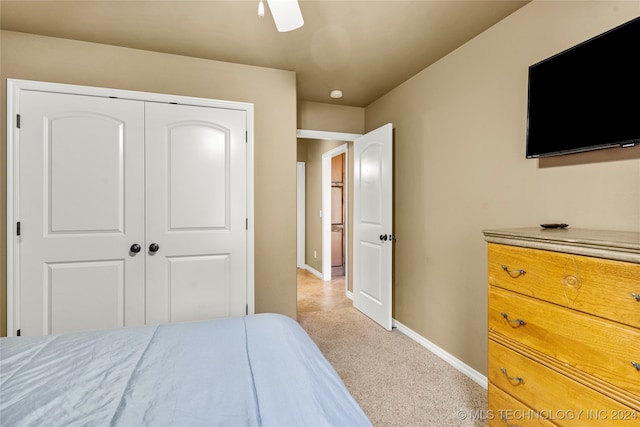 bedroom featuring a closet, light carpet, and ceiling fan