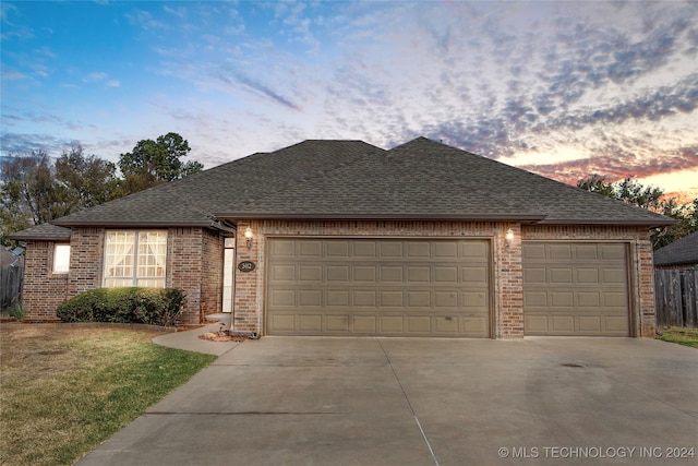 ranch-style home with a yard and a garage