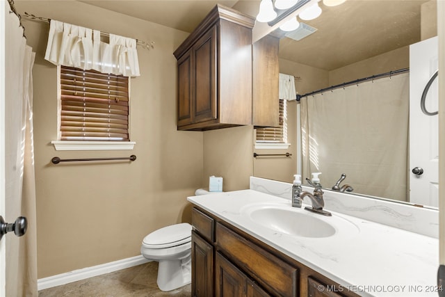 bathroom featuring vanity, toilet, and tile patterned flooring